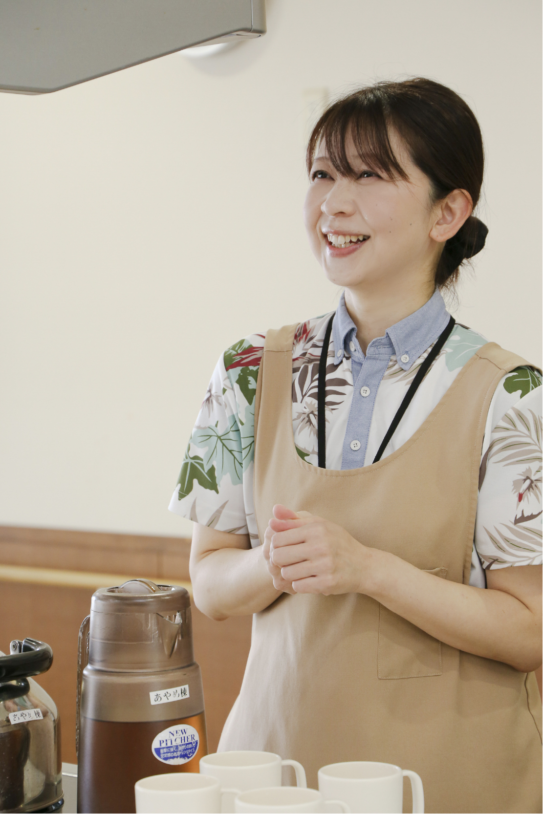 笑顔でお茶を運ぶ女性の写真