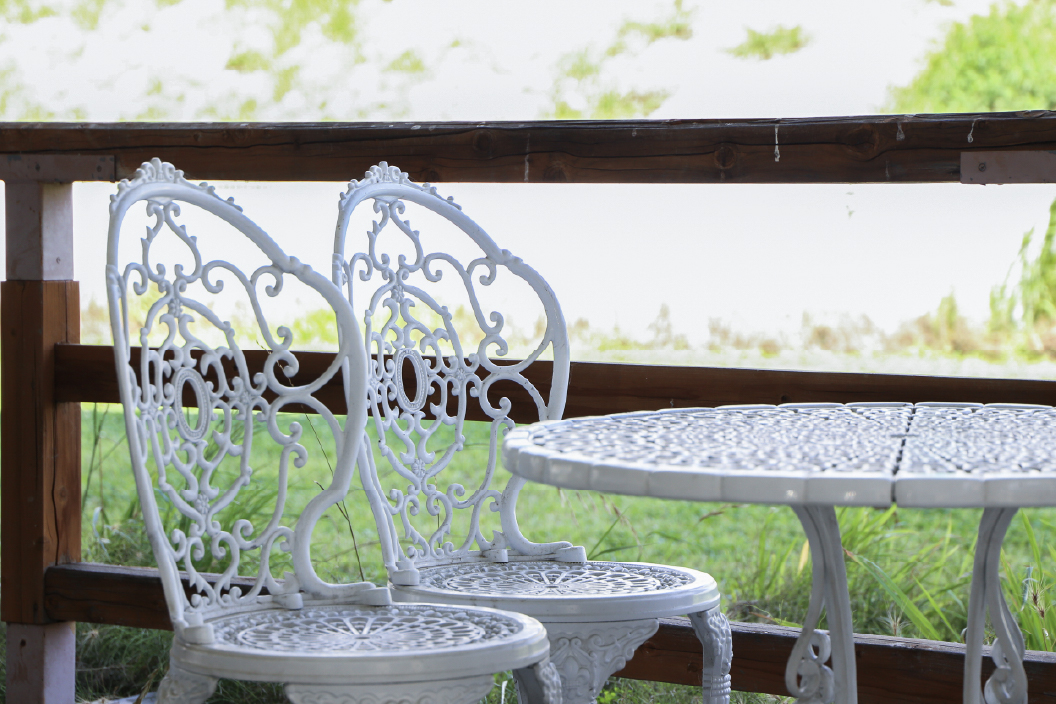 庭園にある白色の椅子と机の写真