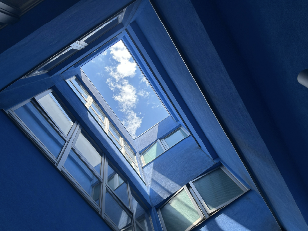 施設内の吹き抜けから青空を見た風景写真