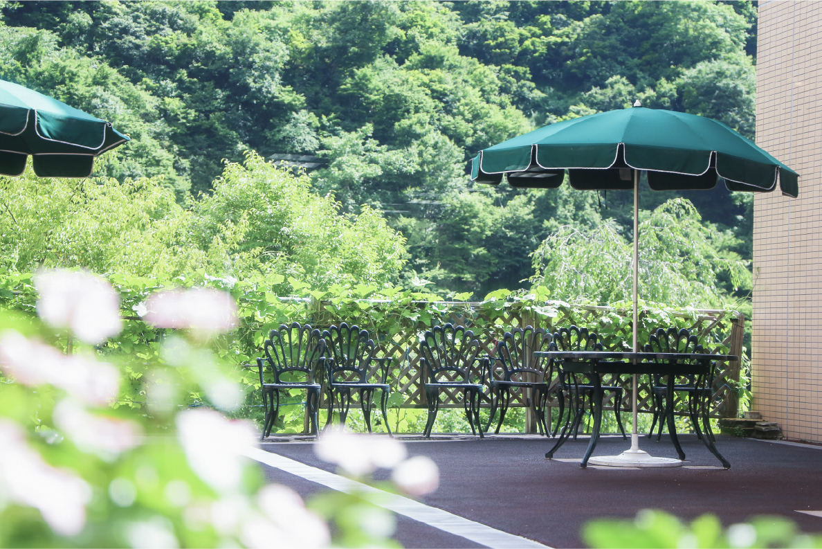 パラソル付き机と椅子のある施設内風景写真